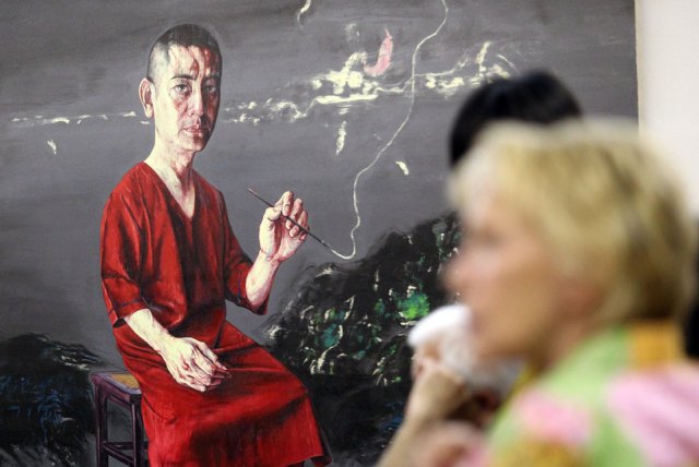 游客在Bulgaria,Sofia国立国外艺术馆的曾梵志作品前